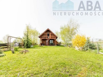 Drewniany domek letniskowy przy linii brzegowej jeziora Popi