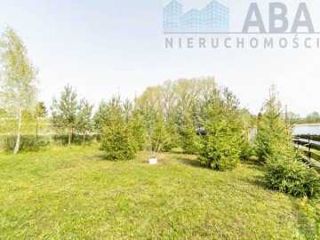 Drewniany domek letniskowy przy linii brzegowej jeziora Popi