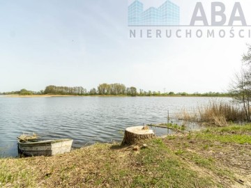 Drewniany domek letniskowy przy linii brzegowej jeziora Popi