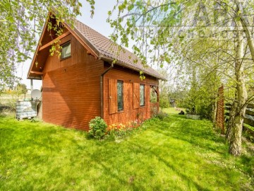 Drewniany domek letniskowy przy linii brzegowej jeziora Popi
