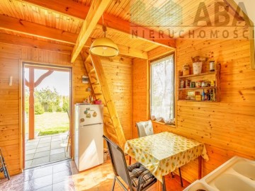 Drewniany domek letniskowy przy linii brzegowej jeziora Popi