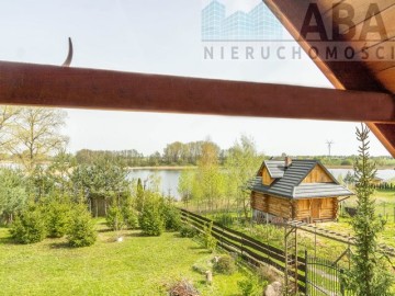 Drewniany domek letniskowy przy linii brzegowej jeziora Popi