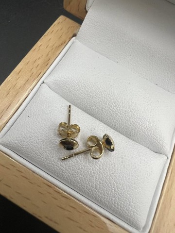 Złote kolczyki z czarnymi oczkami