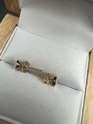 Złote kolczyki z czarnymi oczkami