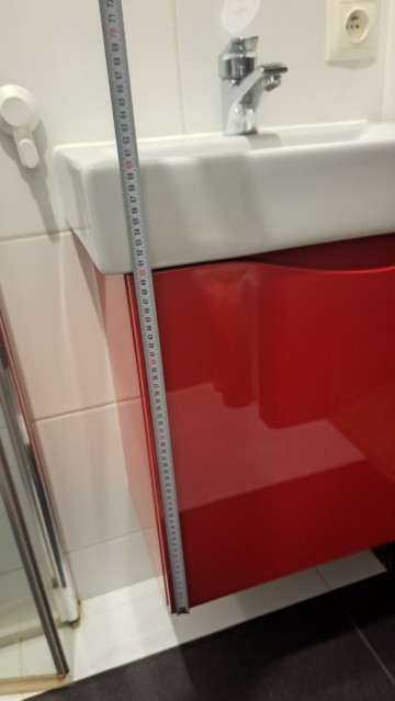 Czerwona szafka łazienkowa z umywalką i kranem