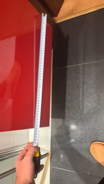 Czerwona szafka łazienkowa z umywalką i kranem