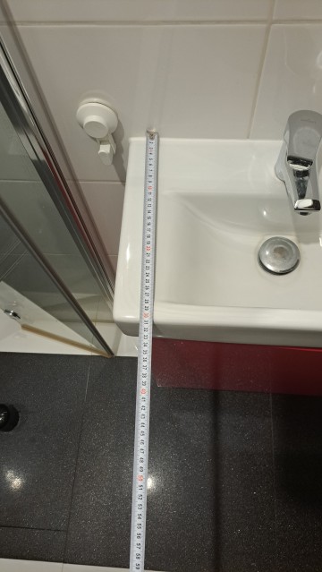 Czerwona szafka łazienkowa z umywalką i kranem